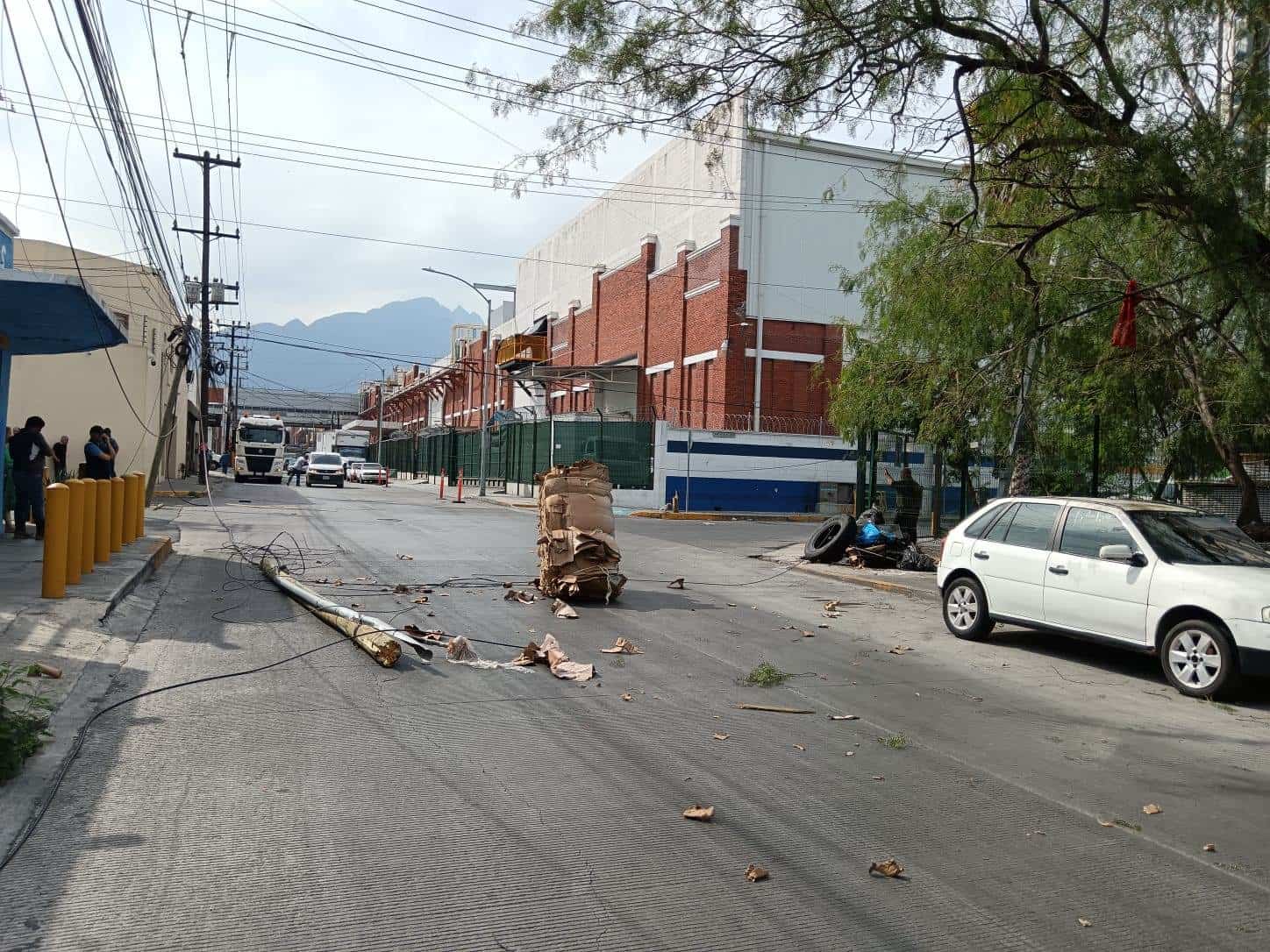 El exceso de altura en la carga que llevaba un tráiler, provocó que derribara cables de telefonía, en el centro de Monterrey.